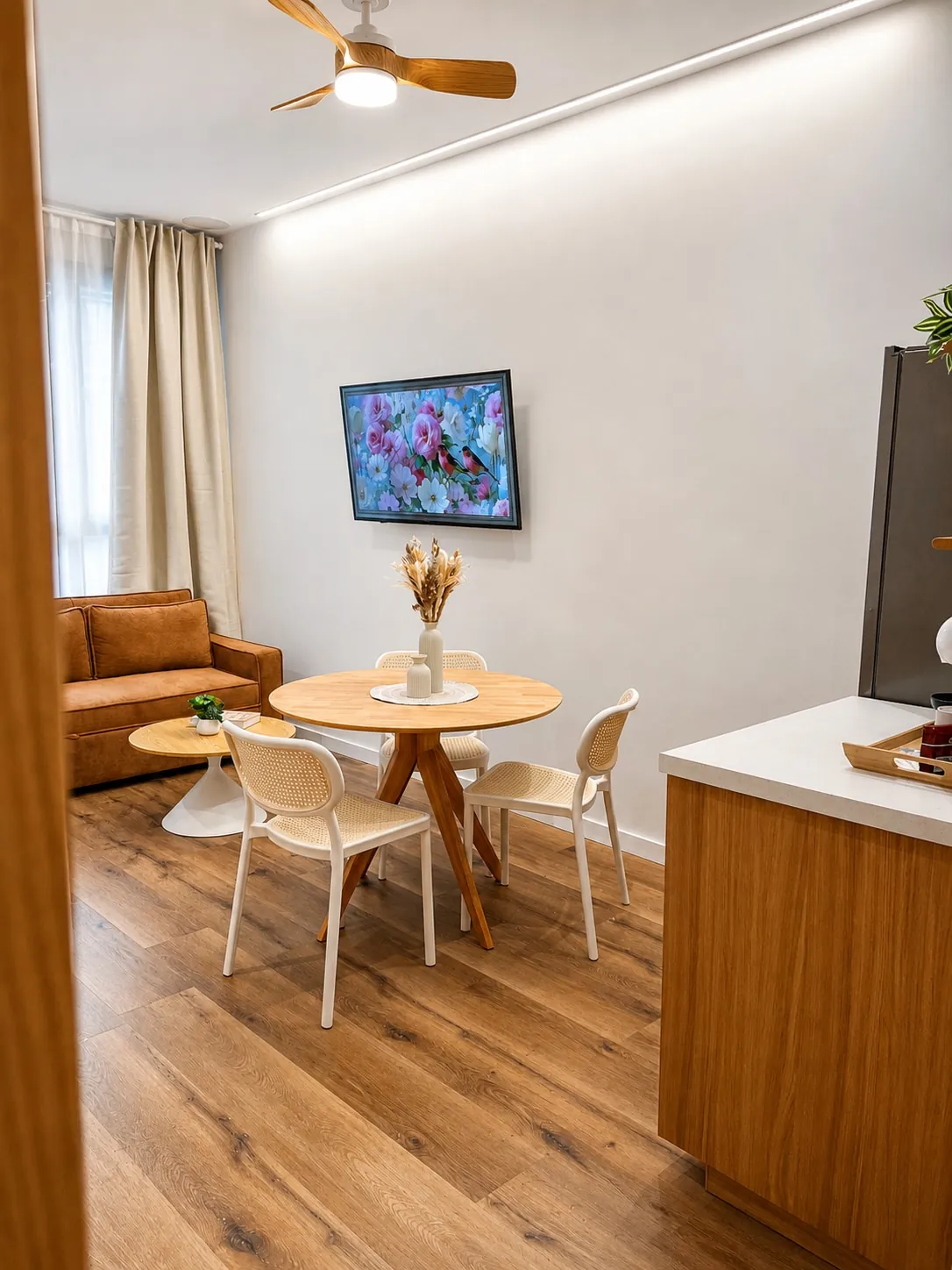 Zona de estar con televisión y ventilador de techo